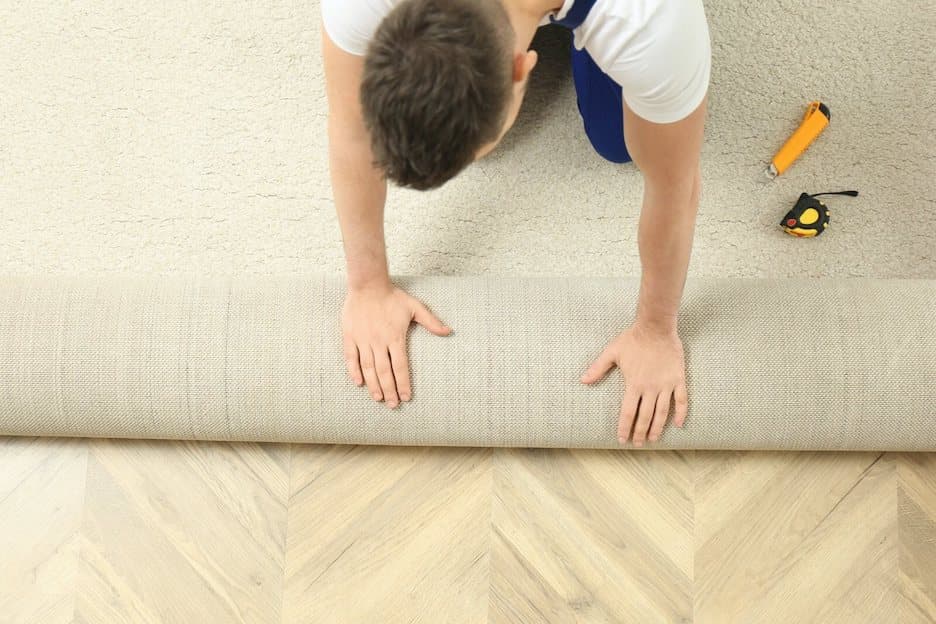 Professional installation crew member rolling out carpet to install